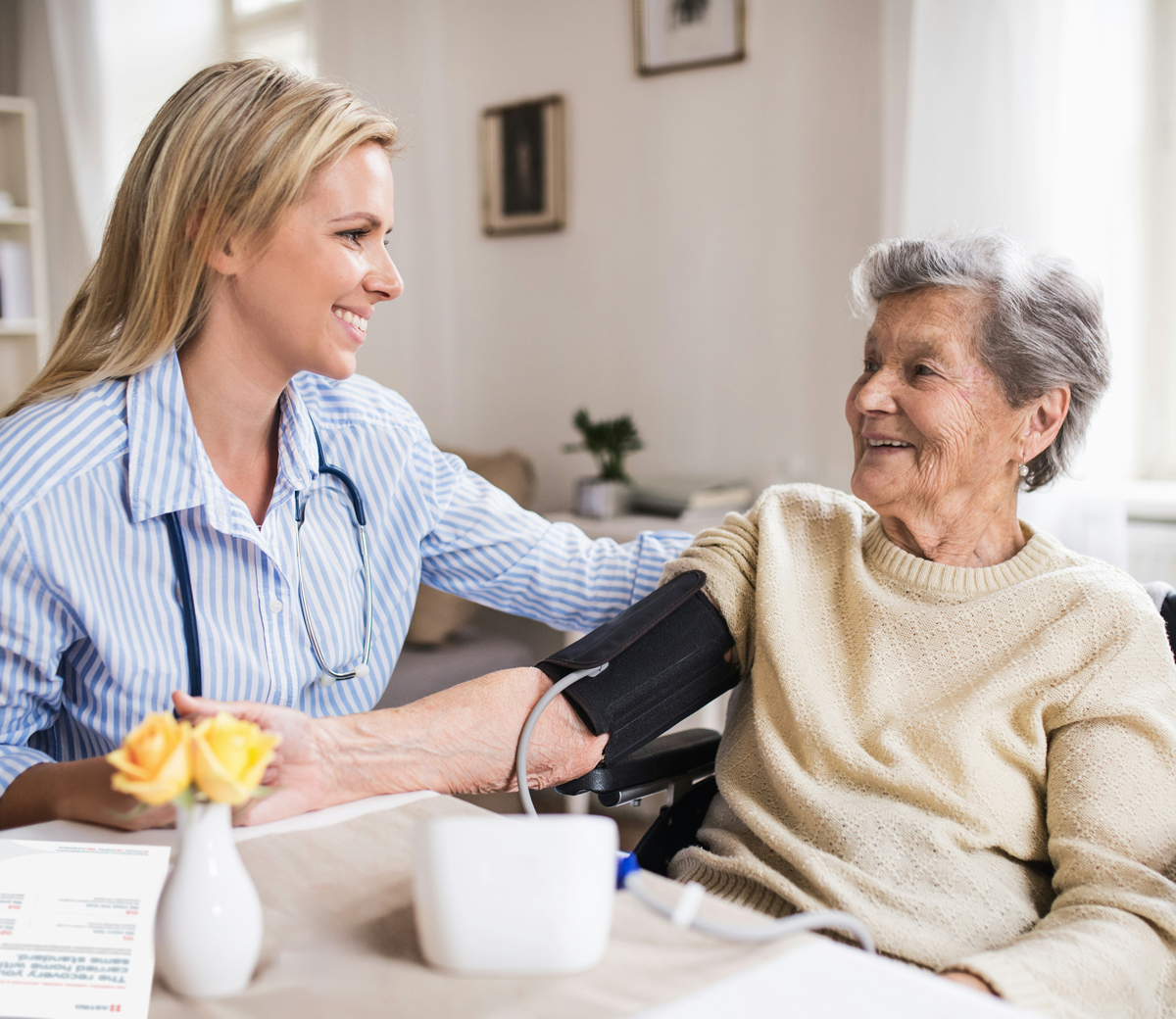 Home health nurse checking blood pressure during in-home patient visit