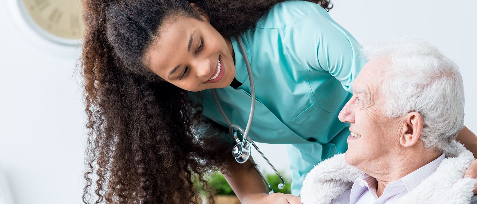 Home health nurse sharing a warm moment with an older patient during an in-home visit